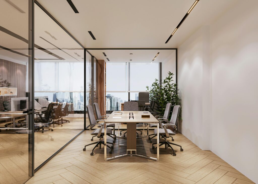 A modern conference room featuring glass walls, natural light, and stylish furniture overlooking a city skyline.